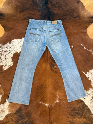 Vintage nudie jeans RegularRalf 2000s - Tjena! Säljer dessa vintage nudie jeans i modellen RegularRalf HomeLaundry, fint skick med nice slitningar på bakfickorna, passar W33/L30, hör av dig vid funderingar!🙌