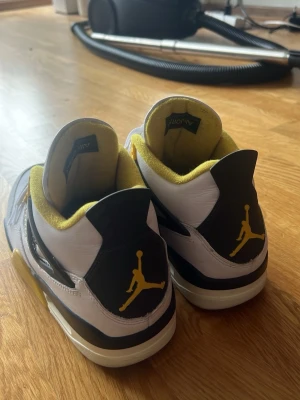 Air Jordan 4 Retro White/Yellow/Black - Air Jordan 4 Retro sneakers i vitt läder med svarta och gula detaljer. Andvända typ 5 gånger. Köpte på sneakers n stuff för 2800. Möts upp i Stockholm.(har kvar låda om man vill ha med det)