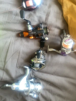 100kr per rulle 450kr för alla - Två fiskerullar i metall och plast, en i svart och orange och en i silver och lila. Båda har vev och är färdigspolade med fiskelina. Perfekt för dig som gillar fiske och vill ha pålitlig utrustning.