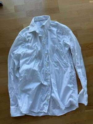 Vit skjorta från Eton, contemporary - Klassisk vit skjorta från Eton i modellen Contemporary. Skjortan har lång ärm, knappar framtill och bred krage. Perfekt för en clean och stilren look. Tillverkad i bomull för en skön känsla och snygg passform.