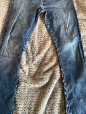 Blå Lee jeans - Säljer ett par blå jeans med rak passform och klassisk femficksdesign. Jeansen har en snygg tvättad look och kontrastsömmar. Perfekta för en avslappnad stil och passar till det mesta. Materialet är denim i bomull.        Lee.    W34.    L34
