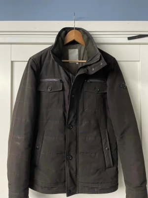 J.Lindeberg fieldjacket - Stilren svart brun fieldjacket från J.Lindeberg storlek M några få defekter passar perfekt nu till våren pris kan diskuteras 