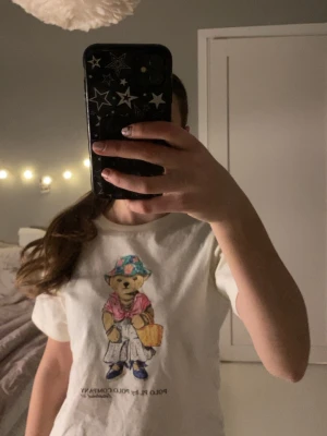 Vit t-shirt med björntryck från Polo PL - Snygg vit t-shirt med en björn på bröstet. Klassisk rund halsringning och korta ärmar. Köpt på Plick. Perfekt för våren och sommaren!💓