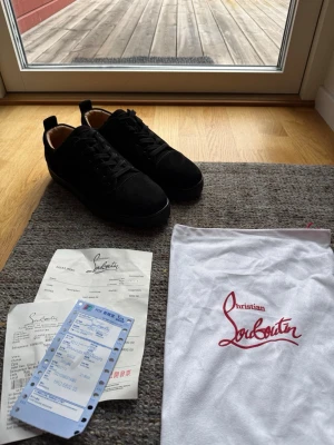 Svarta sneakers från Christian Louboutin - Nu för endast 1499! Pris kan diskuteras! Allt i bilden ingår! Stilrena svarta sneakers från Christian Louboutin i mocka med klassisk låg siluett. Skorna har svarta skosnören och en diskret design med lyxig känsla. Innersulan är ljus och skon har en mjuk, rundad tå. Perfekta för dig som gillar exklusiva märken.