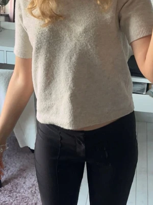 Stickad T-shirt  - Beige stickad T-shirt från Nelly. Lite små nopprig men annars fint skick