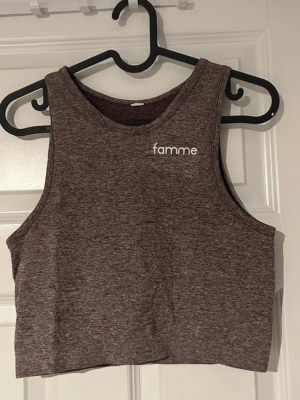 Träningstopp  - Säljer en croppad linnetopp från Famme. Toppen är ärmlös med rund halsringning och har en sportig vibe perfekt till träning eller en avslappnad outfit. Materialet är mjukt och stretchigt för en bekväm passform.(ifrån famme) 