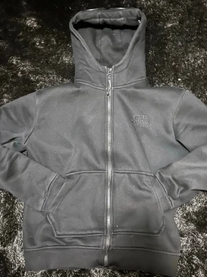 Svart hoodie från C.P. Company - Säljer en svart hoodie från C.P. Company med dragkedja framtill och broderad logga på bröstet. Hoodien har stora fickor framtill och ribbade muddar vid ärmslut och nederkant. Tillverkad i mjukt bomullsmaterial och har en klassisk, avslappnad passform parfekt till sommar kvällar den är som en S 