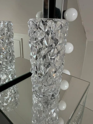 Orrefors vas i kristall, klar - Säljer en snygg och modern vas från Orrefors i klar kristall. Vasen har ett coolt, kantigt mönster som ger ett exklusivt intryck och reflekterar ljuset på ett fett sätt. Perfekt för snittblommor eller som inredningsdetalj.