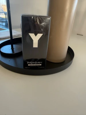 Yves Saint Laurent Y Eau de Parfum - Y Eau de Parfum från Yves Saint Laurent i en elegant svart rektangulär flaska med stor vit Y-logga på framsidan. Förpackningen är stilren och modern, passar dig som gillar exklusiva dofter och snygg design. Volymen är 100 ml.
