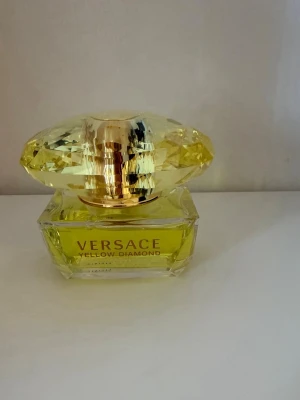 Versace Yellow Diamond edp 50ml  - En parfym för den feminina kvinnan som självsäkert charmar alla hon möter. En sagolik doft med syrliga citroner och frisk päronsorbet i kombination med noter från bergamott och neroli. Den sällsynta elegansen från apelsinblomma och fresia i symbios med lotus skapar en enastående elegans. I basen återfinns sensuella noter av mysk, amber och trä. Topp: Citron, Päronsorbet, Bergamott, Neroli Hjärta: Apelsinblomma, Fresia, Lotus, Mimosa Bas: Amber, Palo Santo trä, Mysk