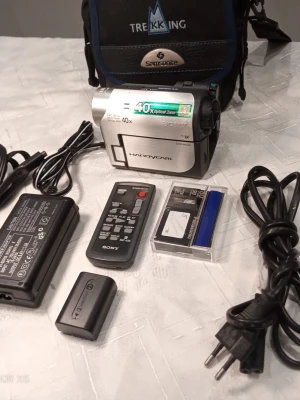 Sony Handycam videokamera med tillbehör - Säljer en silverfärgad Sony Handycam videokamera med 40x optisk zoom. Medföljer fjärrkontroll, laddare, batteri, minneskort och en svart Samsonite väska. Kameran har Nightshot Plus och tydliga knappar på sidan. Perfekt för dig som vill filma och spara minnen.                          Ring vid frågor på 0700441696,   Kameran kan skickas, hämtas i Trollhättan eller i Göteborg