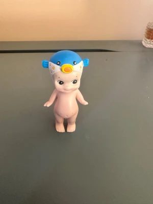 Sonny angel från 2011 rare! - Söt liten samlardocka med en blå och vit fiskmössa med gula detaljer. Dockan har en neutral hudton och står upprätt med armarna utåt sidorna. Tillverkad i plast och har detaljerade ansiktsdrag på mössan.