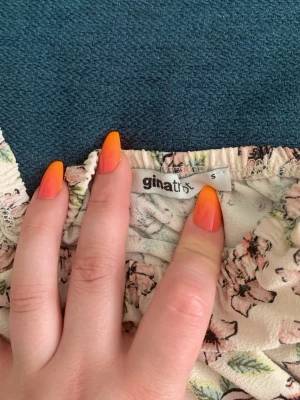 Blommig offshoulder topp Gina Tricot - Söt offshoulder topp från Gina Tricot i ljusbeige med blommigt mönster i rosa och grönt. Toppen har långa ärmar och elastisk kant upptill för en snygg passform. Perfekt för vår och sommar!