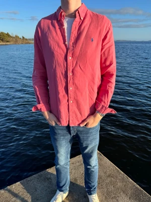 Rosa linneskjorta  från Polo Ralph Lauren - Tjena hörni! Vi säljer nu denna toppklass linne skjortan från Ralph Lauren i storlek L men sitter även som M. Skicket är helt perfekt till sommaren med inte en enda skråma. Vårt pris endast 449kr men kan sänkas vid snabb och smidig affär, linne material. Skick 10/10. Hör av er vid frågor // studio II Resell 💙