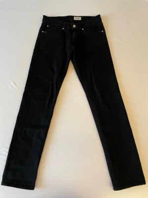 Svarta raka jeans från Tiger of Sweden - Snygga svarta jeans från Tiger of Sweden med rak passform och klassisk femficksdesign. Modellen är Rex, med slim fit. Nypris 1599.
