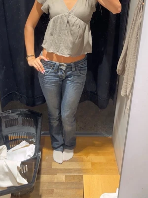 Mörkblå bootcut jeans med låg midja - Snygga mörkblå bootcut jeans med låg midja. Jeansen har kontrastsömmar och en tvättad look som ger en vintage vibe. Jag är 176 cm som referens. Köpta vintage och därav oklar storlek, skulle gissa på 34 eller 36. 