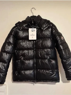 Moncler Jacka - Moncler vinterjacka, väldigt bra skick förutom hängaren inuti som gått sönder (bild 6) Köpt ifrån Vestire Collect. Lappana har jag klippt av men alla finns kvar och även påse. 