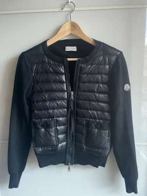 Moncler Cardigan - Snygg svart cardiganjacka från Moncler med quiltad, glansig front och två fickor med knapp. Nästan helt ny med mycket bra kvalitet💕 Nypris ca 9500, pris går att diskuteras💕