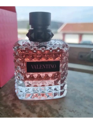 Valentino Donna Born In Roma parfym - Valentino Donna Born In Roma parfym med en lyxig, rosa glasflaska dekorerad med nitar och svart kork. Kommer i en snygg rosa kartong med svart etikett. Det är nästan full 90-95% kvar jag använder inte den fick den som en present. Om ni har några frågar så det ba fråga 😁