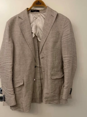 Oscar Jacobson Linné kavaj  - En beige Linné kavaj från Oscar Jacobson. Kavajen är i bra skick det ända är att armarna är lite skrynkliga. 