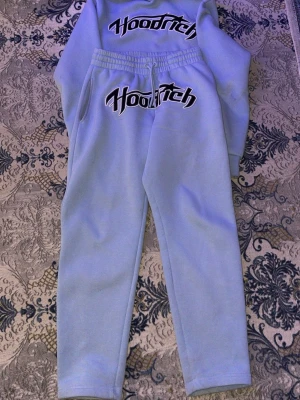 Ljusblå Hoodrich loungewear set - Säljer ett ljusblått loungewear set från Hoodrich med matchande sweatshirt och byxor. Båda delarna har Hoodrich-loggan tryckt i svart och vitt framtill. Setet har avslappnad passform och mjukt material, perfekt för chill dagar hemma.