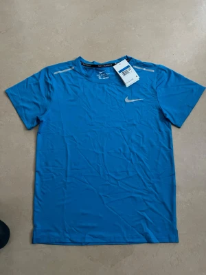 Nike miler T-shirt blå storlek medium  - Ny Nike t-shirt i stilren design. Perfekt basplagg till gym/vardag/sommar.  Oanvänd Populär modell Säljs snabbt  Skickas direkt 📦