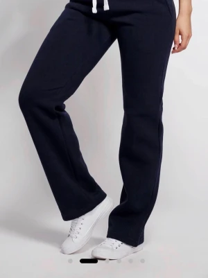 Mörkblå mjukisbyxor med dragsko - Säljer mina mörkblå russemerch mjukisbyxor med raka ben och vita snören vidi midjan. Byxorna har fickor på sidorna och är gjorda i mjukt sweatshirtmaterial som är riktigt skönt. Perfekta för chill dagar eller när du vill vara bekväm. Byxorna är storlek xxs till xs fast det är större i storlek. De är i bra skick och säljer de för ungefär hälften av ordinarie pris!                                     Som sagt är jag öppen för prissänkning eller eventuella frågor om mjukisbyxorna! 🎀