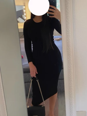 Svart ribbad långklänning - Snygg svart långklänning med rund halsringning och lång ärm. Klänningen är ribbad och har en tight passform🌸