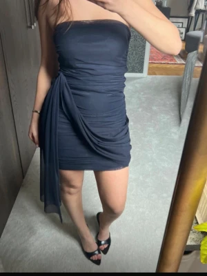 Bandeau klänning - Axelbandslös draperarad klänning med ”släp” på sidan, riktigt fin och i bra kvalitet, köpt på Zalando men osäker på märket. Endast använd en gång. Nypris ca 1000:- 