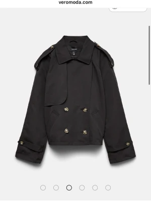 Kort svart trenchcoat från Vero Moda - Sitter som en S fast storlek XL, liten i storlek! Endast använd 2 ggr. Nypris ligger vid 600