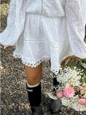 Vit broderad kortklänning från Nelly - pris kan diskuteras! Superfin vit kortklänning från Nelly med broderade detaljer och volangkant. Klänningen har långärmade ärmar och är tillverkad i bomull, vilket gör den både luftig och bekväm. Perfekt för student,konfirmation o massa av sommarens alla tillfällen! Den är köpt för 600kr och är Aldrig använd och har till och med lappen kvar. Köpte den till förra årets skolavslutning men då passade den inte så den har  inte kommit till användning!