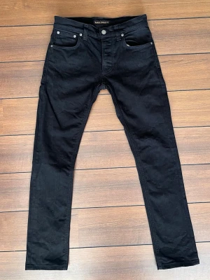 Nudie jeans 30/34 - Säljer mina svarta Nudiejeans, dem är i mycket bra skick utan skador eller några defekter! Det är grim tims i storlek 30/34. Hör gärna av dig vid frågor 😄!   Fler liknande plagg finns på min profil!