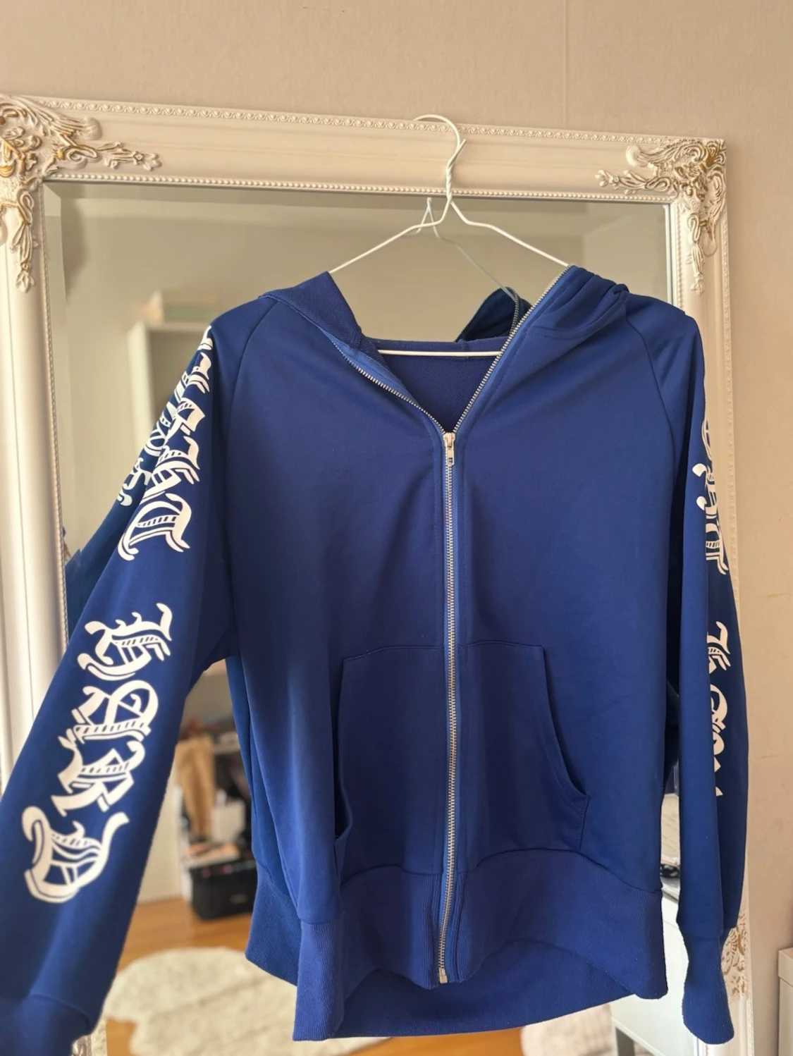 Blå hoodie med tryck på ärmarna