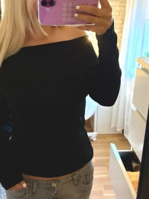 Svart offshoulder långärmad tröja - Snygg svart offshoulder tröja med långa ärm och figurnära passform. Står M på lappen men uppskattas till S !! 💕köpt här på plick men används inte😊bilden är inte min!