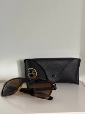 Ray-Ban boyfriend solglasögon - Snygga solglasögon från Ray-Ban med brunmelerade bågar och bruna glas. Klassisk fyrkantig form och levereras med original svart fodral i skinnimitation. Perfekta för att lyfta din stil under soliga dagar. Köpt på Åhléns i Stockholm förra sommaren på rea från 2100kr till 1790kr, perfekt skick och det är polariserat glas. Använda inte mer än 30 gånger och de är nytvättade och fräscha.
