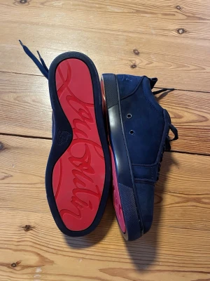 Mörk blåa sneakers med röd sula - Blåa sneakers med röd sula. Skorna är aldrig använda, alltså i sprillans nytt skick 🙌 Priset är ej hugget i sten, det kan förändras vid en snabb affär‼️