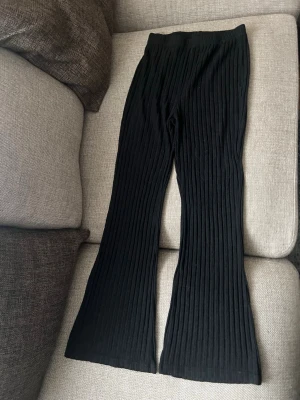 Svarta ribbade leggings med utsvängda ben - Säljer ett par svarta leggings med ribbad struktur och utsvängda ben. De har hög midja och är gjorda i ett mjukt, stretchigt material som är riktigt skönt att bära. Perfekta för dig som gillar en trendig och avslappnad look. Pris går o diskutera 💞💞💕