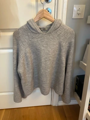 Grå stickad hoodie i ullmix - Grå stickad från Gina 