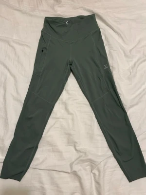 Gröna höga leggings  - Snygga gröna leggings med hög midja och markerade sömmar som framhäver formerna. Stretchigt material som sitter tight och bekvämt. Perfekta för träning eller chill. 