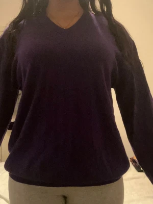 Lila v-ringad tröja från Orvis - En stilren lila tröja från Orvis med v-ringning och långa ärmar. Tröjan är enkel och passar perfekt till olika outfits. Tillverkad i mjukt material som känns skönt mot huden. Klassisk passform och ribbade muddar vid ärmslut och nederkant. Storlek men passar mig som är M.