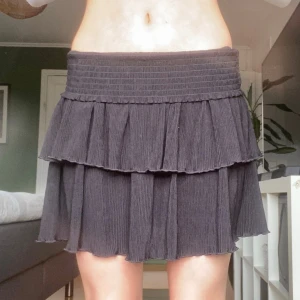 Svart volangkjol💗 - Säljer en svart kortkjol med volang och ribbad struktur. Kjolen har två lager volanger och bred resår i midjan som ger en bekväm passform. Perfekt för dig som vill ha en trendig och bekväm kjol i sommar. Kontakta mig om ni vill ha fler bilder eller undrar över något!💗(På första bilden är resårkanten ner vikt)