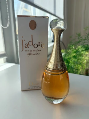 J'adore Infinissime Eau de Parfum Dior - J'adore Infinissime Eau de Parfum från Dior i en elegant droppformad glasflaska med guldfärgad hals och transparent klotformad kork. Parfymen har en varm bärnstensfärgad vätska och levereras i originalförpackning. Flaskan rymmer 100 ml. Ny pris 1950kr 