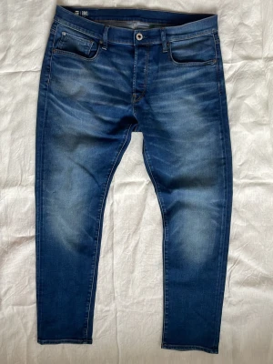 Blåa jeans G-star raw | 34 - Sjukt snygga blå jeans från G-star raw med snygga slitningar | Skick: Mycket bra | Strl: W34 L30 | Modellen är 175 cm och väger 65 kg | Hör av dig vid funderingar ⁉️