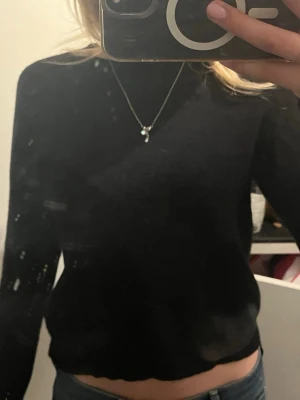 Svart stickad tröja - En enkel och stilren svart stickad tröja med rund hals och långa ärmar. Den sticks inte!!