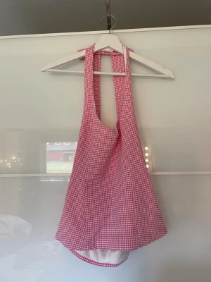 Rutig rosa topp med knytband - Superfin rosa och vit rutig linnetopp från Zara med breda knytband i nacken och öppen rygg. Toppen har en lätt utsvängd passform och dragkedja i sidan för enkel påklädning. Perfekt för dig som vill sticka ut med en söt och trendig look. Helt ny med prislapp. Säljer den för att den var förliten.