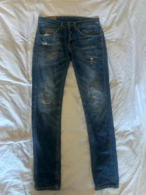 Blå slitna dondup jeans med skinny fit - Säljer mina blå dondup jeans då de är för små de är skinny fit och slitna detaljer på både fram- och baksida. Jeansen har klassisk femficksdesign och är tillverkade i denim. De är i riktigt bra skick och perfekta för en go outfit 