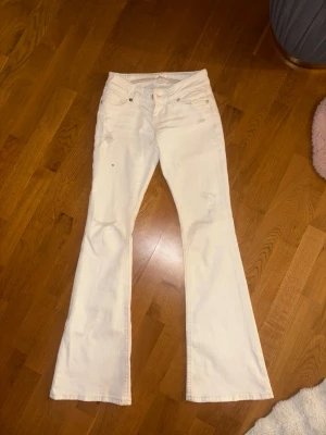 Vita bootcut jeans från Ginatricot - Snygga vita bootcut jeans från Ginatricot med slitna detaljer och klassisk femficksdesign. Jeansen har utsvängda ben och är tillverkade i ett mjukt bomullsmaterial med lite stretch. Perfekta för dig som vill ha en trendig och avslappnad look.