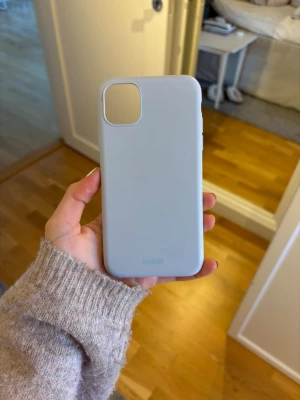 Ljusblått mobilskal från Holdit - Snyggt ljusblått mobilskal från Holdit med stilren design. Skalet är gjort i mjukt silikonmaterial som ger ett bra grepp och skyddar mobilen mot repor och stötar. Passar modeller med större kameralins. Perfekt för dig som vill ha ett enkelt och fräscht skal.