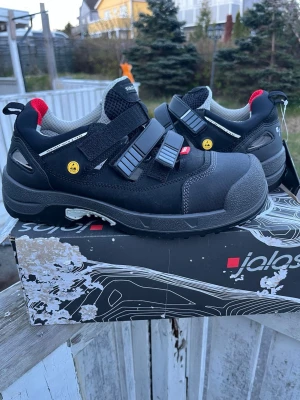 Svarta sneakers från Jalas med kardborre - Svarta sneakers från Jalas med grå och röda detaljer. Skorna har två breda kardborreband, slitstark ovandel i textil och syntet samt förstärkt tåparti. Insidan är vadderad för extra komfort och sulan är robust och greppvänlig.                                      Orginal pris 3500