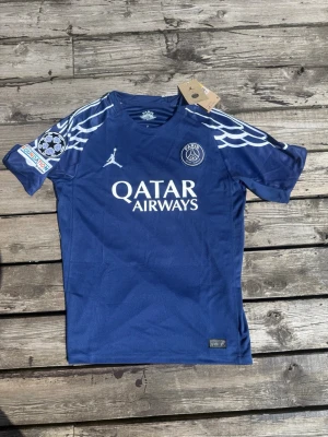 PSG matchtröja O.Dembélé #10 blå - Snygg blå PSG matchtröja med O.Dembélé och nummer 10 på ryggen. Tröjan har vita detaljer, vingmönster på axlarna, Champions League-märke på ärmen och Qatar Airways som sponsor framtill. Tillverkad i lätt och ventilerande material. Helt ny, Pris kan diskuteras